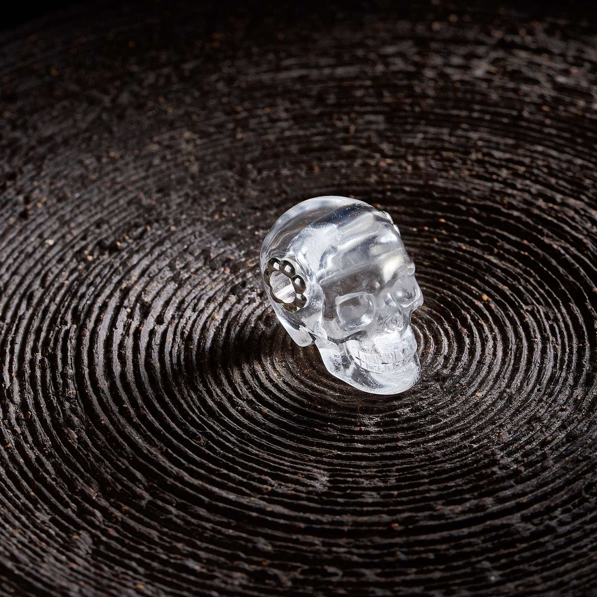 1.0" Clear Quartz Crystal Skull Necklace - Side View on Natural Wood