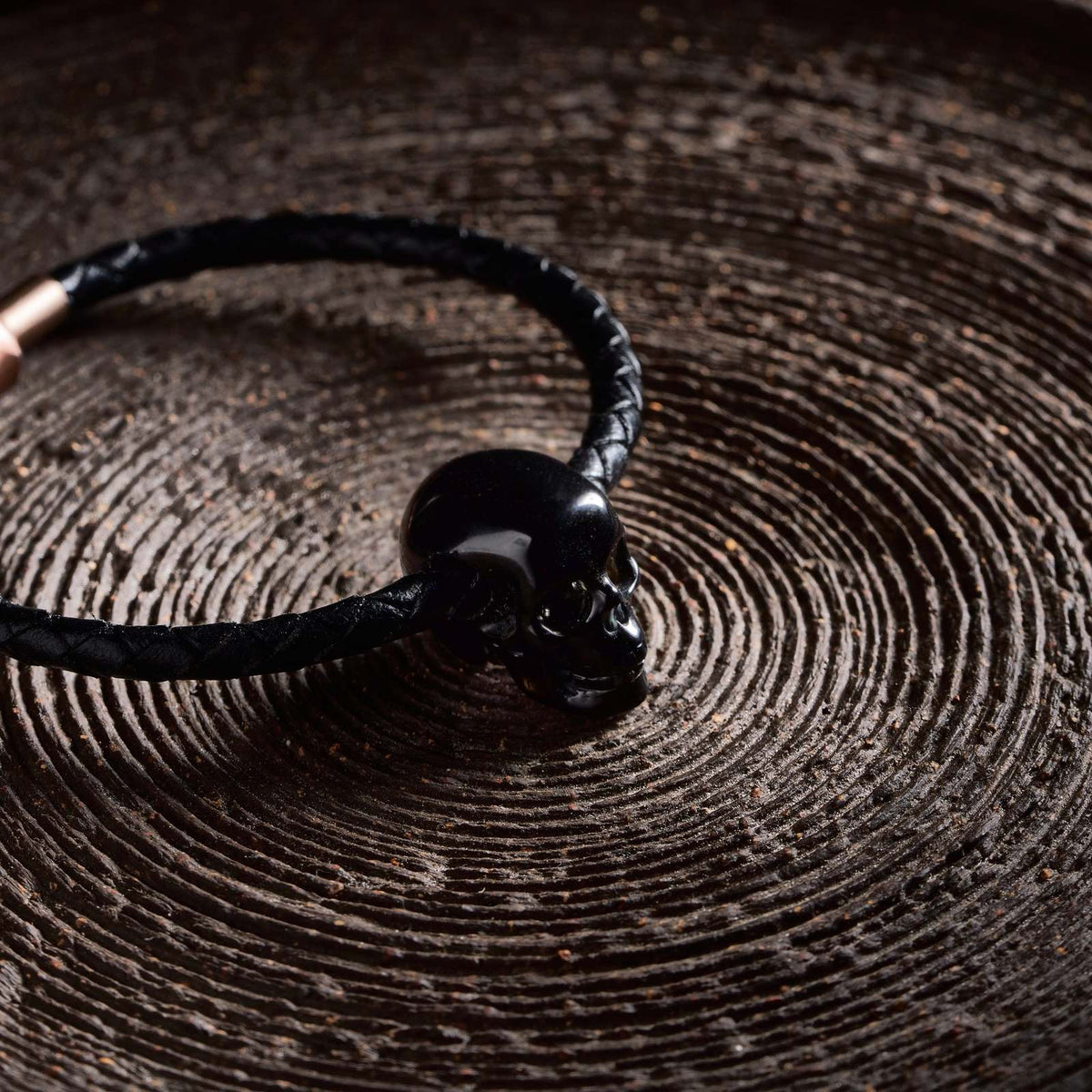 1.0" Black Obsidian Crystal Skull Necklace - Side View on Natural Wood
