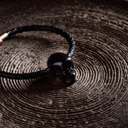 1.0" Black Obsidian Crystal Skull Necklace - Side View on Natural Wood